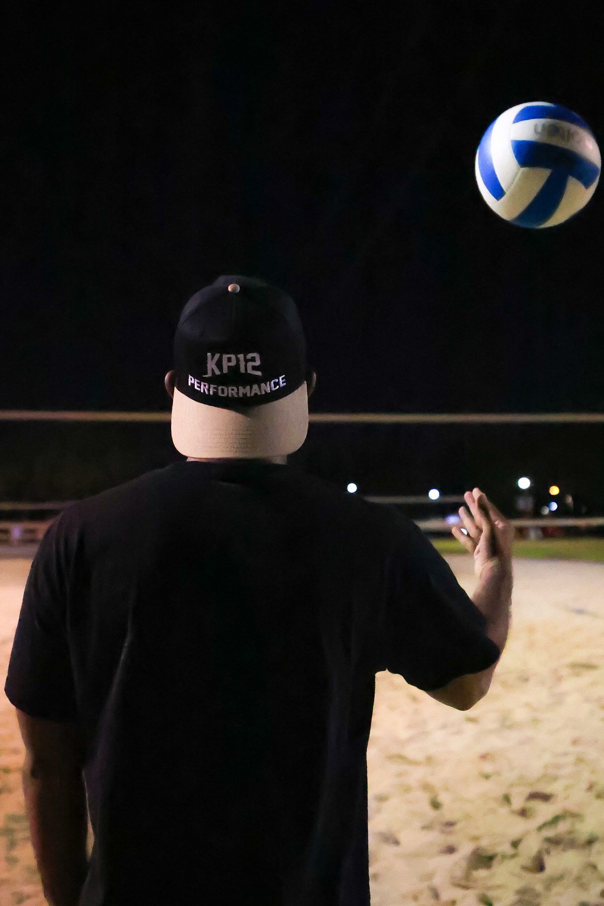 KP12 Performance coach watching a volleyball on the court at night